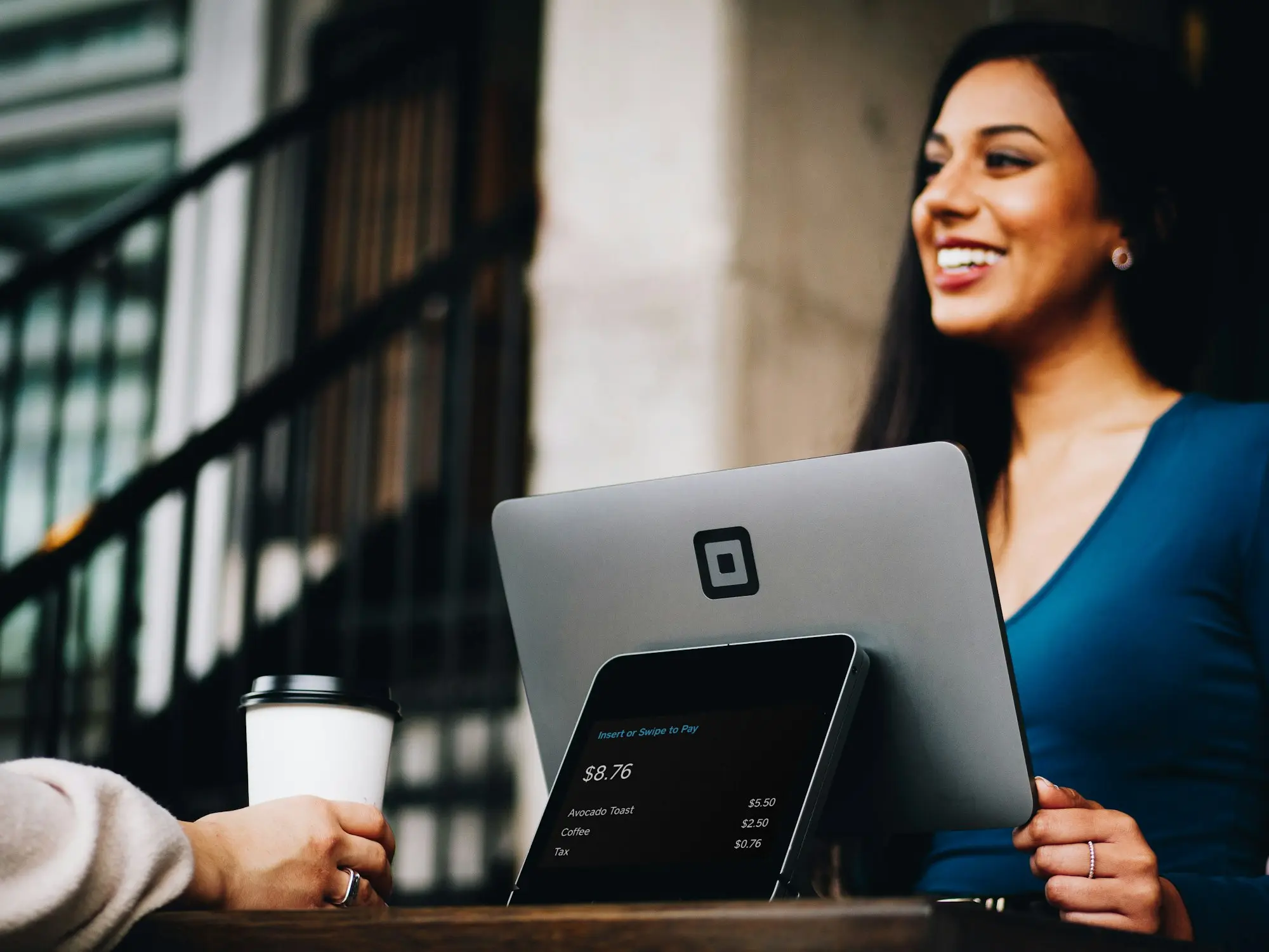 Business owner smiling while reviewing payroll on a tablet