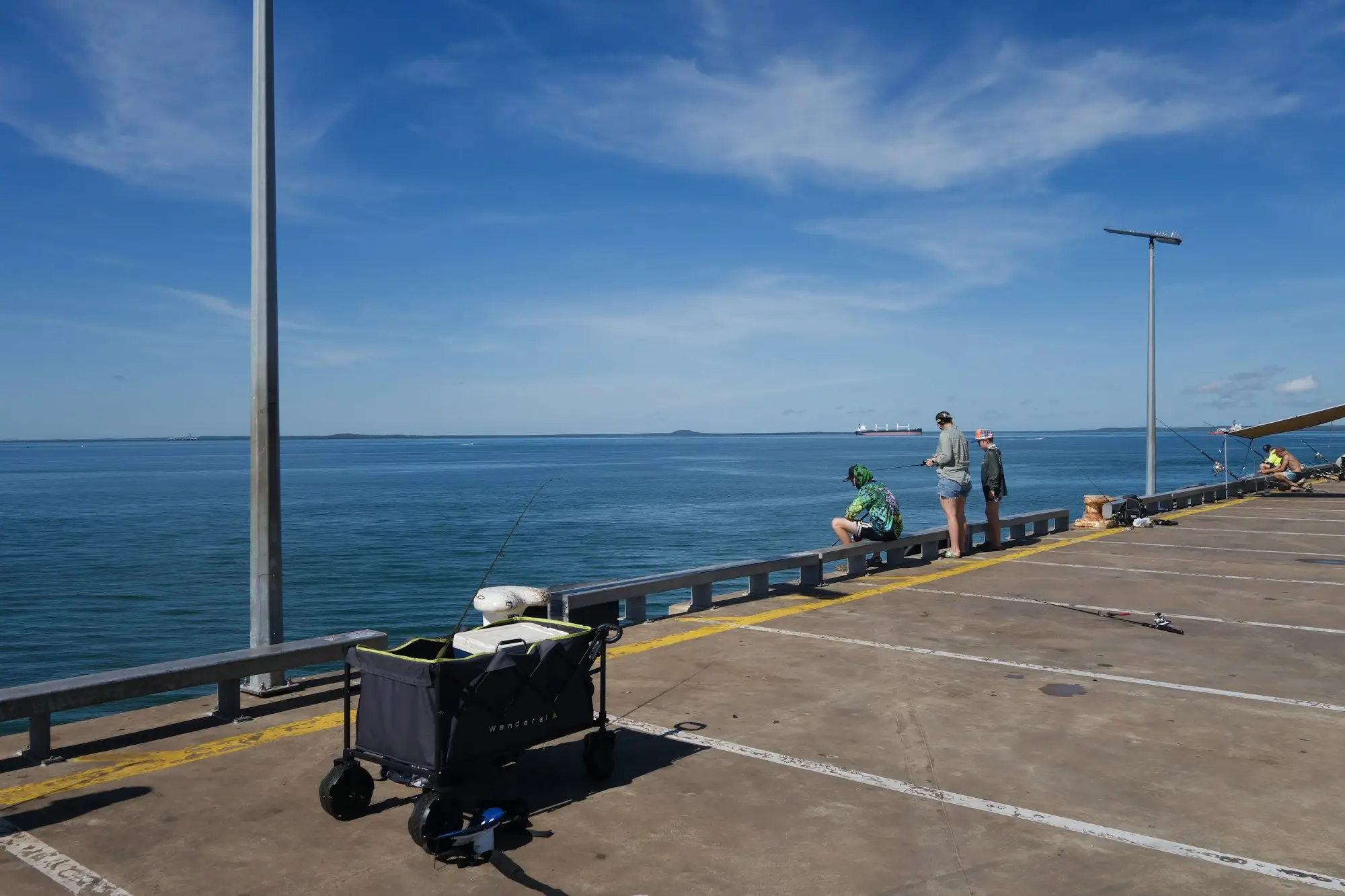 Darwin jetty on a clear day with people fishing off the end